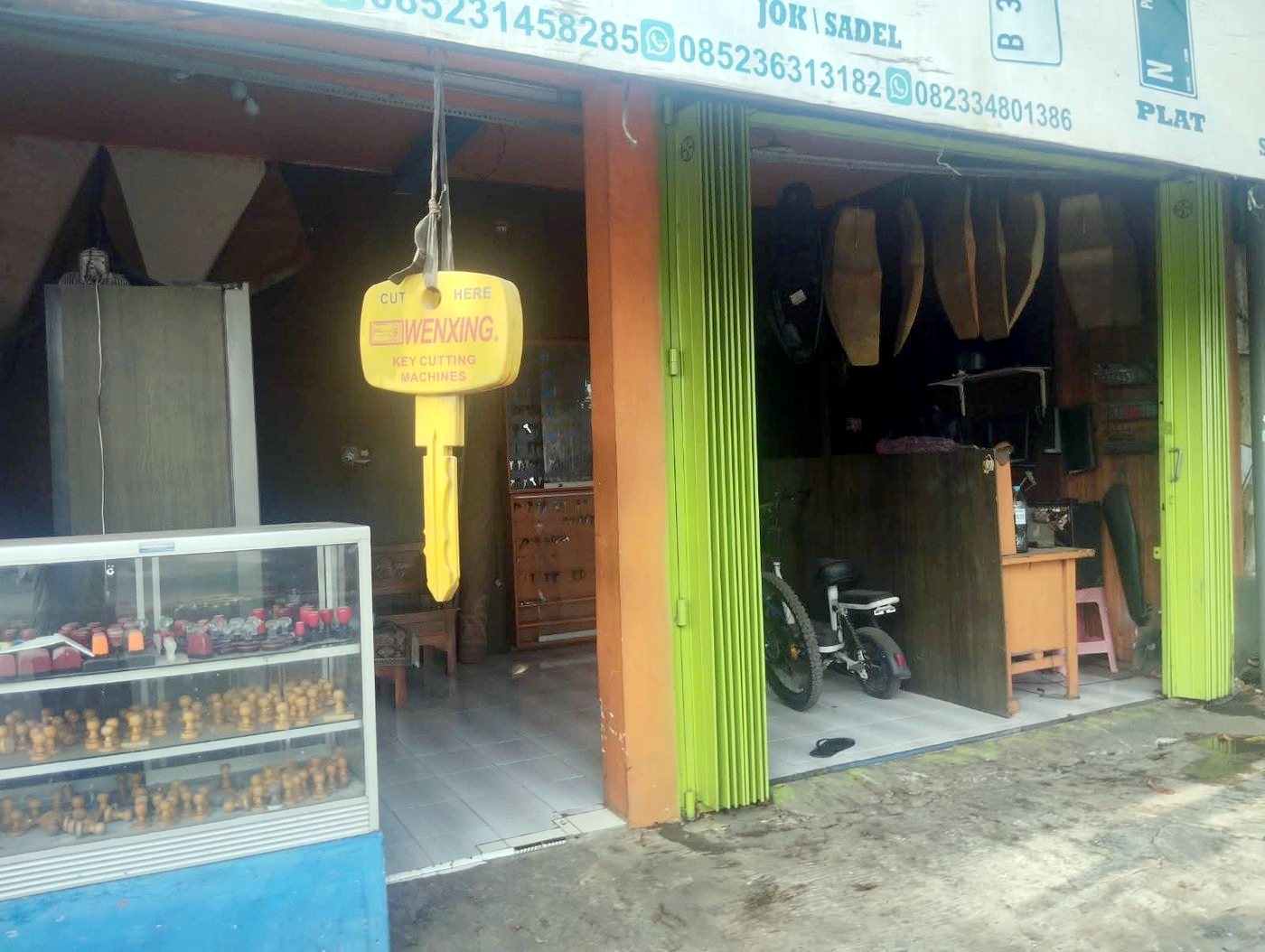 Tampak depan toko Ahli Kunci Kraksaan Pajarakan dengan kunci kuning besar tergantung dan etalase stempel